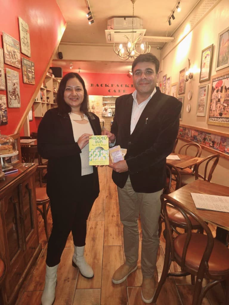 Mystic Maya 🌻 presenting Mirror Hub book in a cafe setting