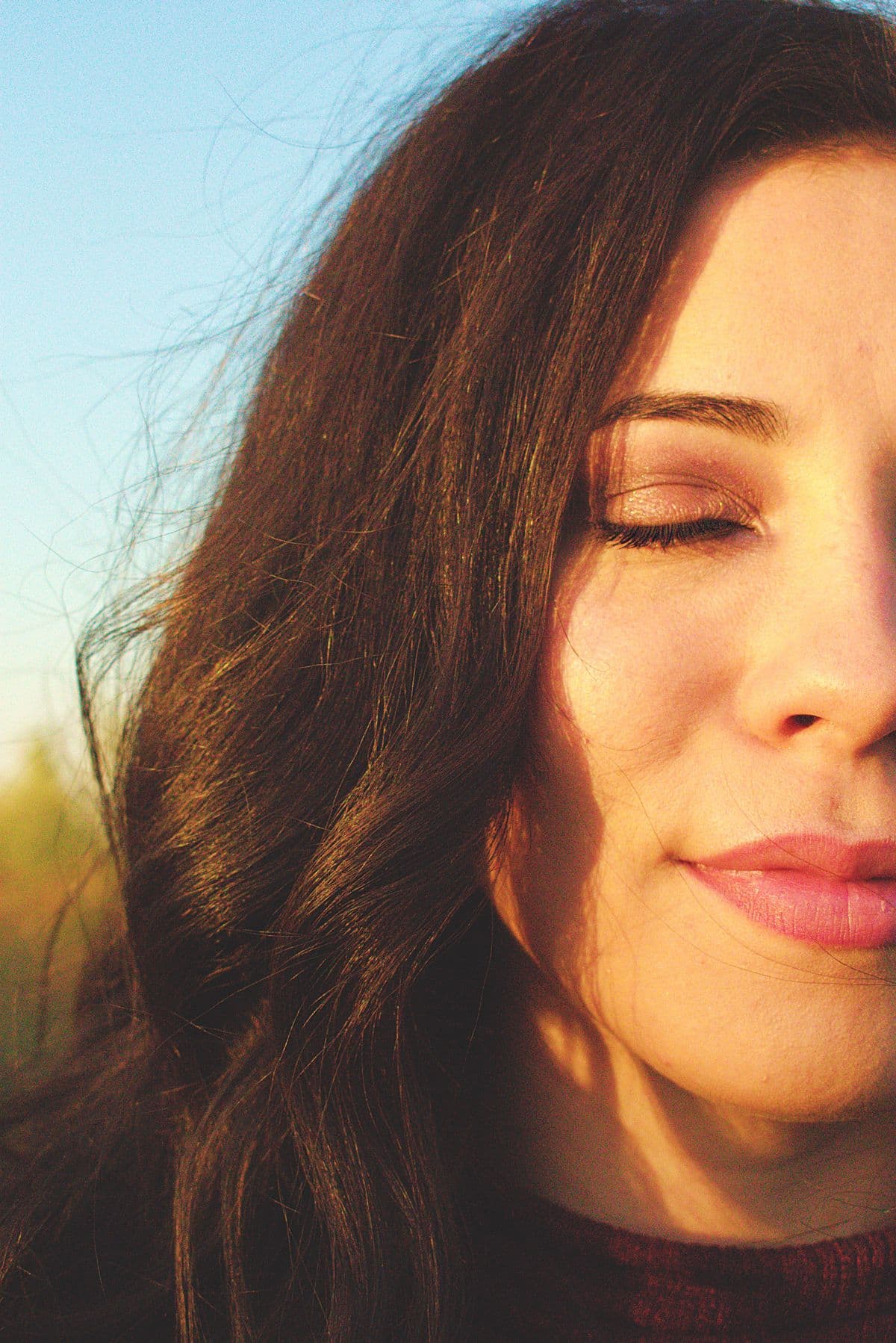 A woman at peace with her eyes closed in warm golden light